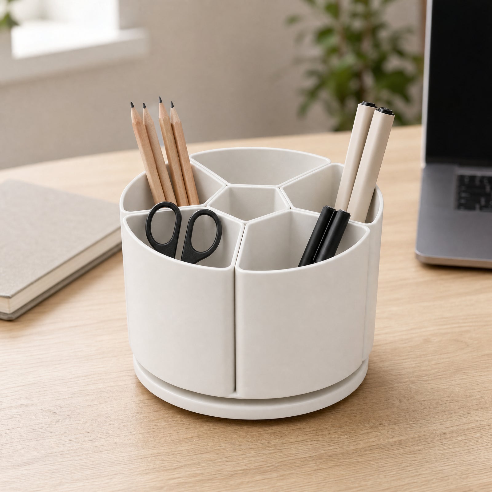Rotating desktop organiser holding plain pens pencils and scissors on a desk